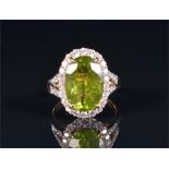 An 18ct yellow gold, diamond, and peridot ring set with an oval cut peridot of approximately 6.0