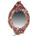 An unusual 19th century French folk art leather framed wall mirror of oval form the tanned leather-