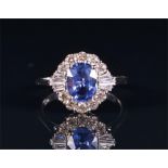 An 18ct white gold, diamond, and sapphire cluster ring centred with an oval cut sapphire of