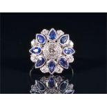 An 18ct white gold, diamond, and sapphire circular cluster ring centred with a round brilliant-cut