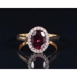 A 9ct yellow gold, diamond, and garnet ring set with an oval-cut garnet of approximately 1.20