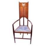 An Art Nouveau mahogany high back armchair in the style of Mackintosh, with inlaid device to the top