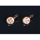 A pair of yellow metal and enamel earrings the circular mounts decorated with dark blue enamel