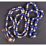 A lapis lazuli and pearl necklace of graduated rounded lapis beads alternated with pearls,