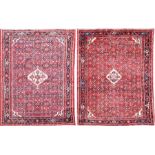 A pair of Persian rugs with a red ground and geometric patterning, 207 x 151 cm.