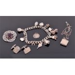 A silver charm bracelet suspended with various charms including a shell, a motorcar, penny