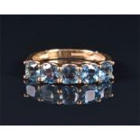 A 9ct yellow gold and blue topaz ring set with a line of five round-cut topaz, size K, 2.2 grams.