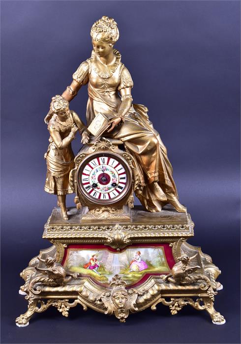 A late 19th century French spelter mantel clock formed as a woman and child reading a book, upon a