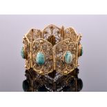 An antique brass and scarab bracelet with openwork panels set with Egyptian turquoise glazed