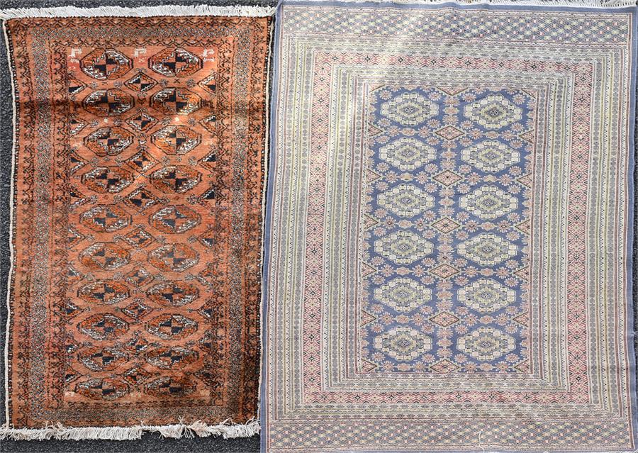 A small Eastern wool work rug  with central mauve field populated by kite shaped medallions within