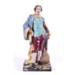 A large Continental ceramic figurine of a well dressed aristocrat in 18th century garb, with a large