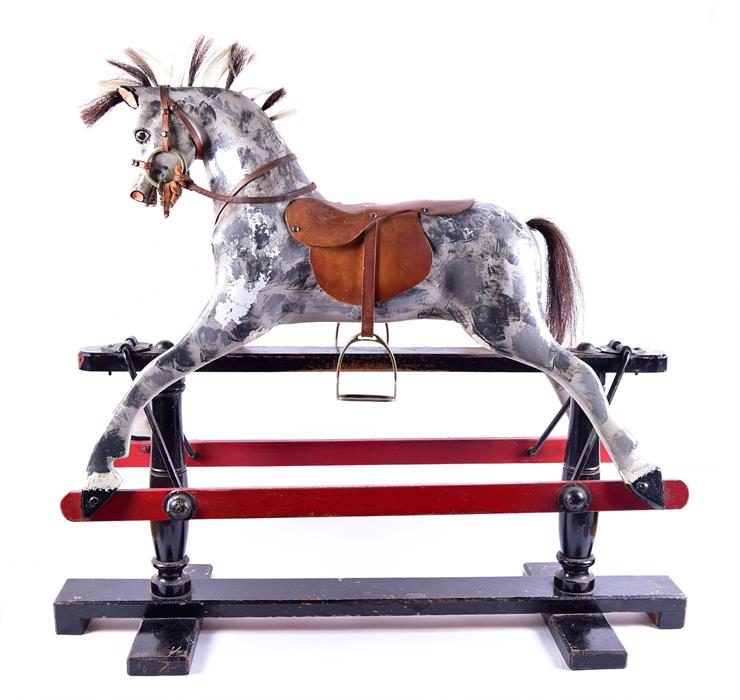 An Edwardian painted rocking horse on a blackened swinging frame, the dappled grey mount adorned