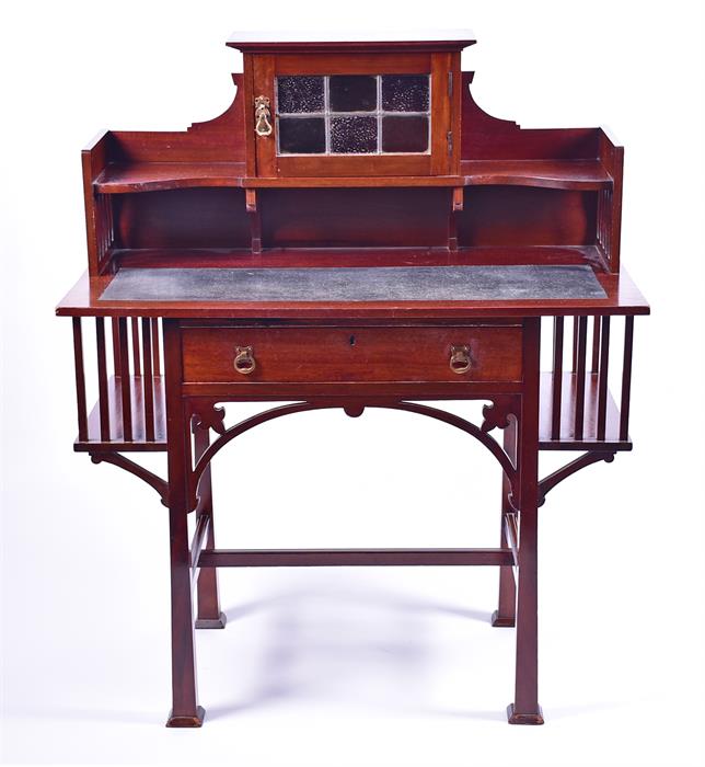 An Art Nouveau mahogany writing desk the top with lead glazed door, and flanked by small shelves,