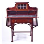 An Art Nouveau mahogany writing desk the top with lead glazed door, and flanked by small shelves,