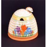 A Clarice Cliff Crocus pattern honey skep / pot  the lid with a bee finial, stamped Clarice Cliff,