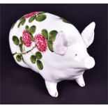 A Wemyss seated pig decorated in the flowering clover pattern  with highlighted painted facial and