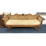 A Regency style bergere scroll end sofa with cane work back and arms, well carved frame with