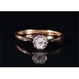 A yellow metal and solitaire diamond ring illusion set with a round brilliant-cut diamond of