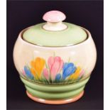 A Clarice Cliff lidded preserve jar in the Crocus pattern with finial lid, 10 cm high, marked to