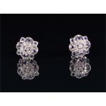 A pair of 18ct white gold, diamond and sapphire ear studs the openwork mounts millegrain set with