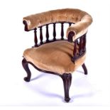 An Edwardian upholstered mahogany club chair with turned baluster gallery back, on swept cabriole