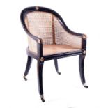 Attributed to Gillow, an early 19th century ebonised bergere armchair rail back with carved gilt