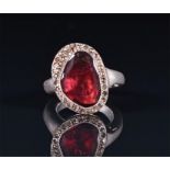 An unusual silver, diamond, and almandine garnet ring set with a triangular faceted garnet