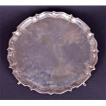 An early 20th century circular silver salver on four feet Sheffield, by Herbert Edward Barker &