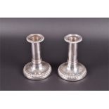 A pair of Georgian silver short candlesticks of weighted, plain form indistinct marks, 13.5cm