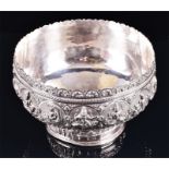 A large Burmese silver pedestal bowl with detailed repousse decoration to the border depicting