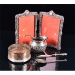 A small collection of silver items comprising: an Edwardian milk jug, a wine coaster, a folding