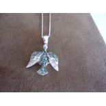Delicate bird pendant with blue and white diamonds set in 18k white gold.Total diamond weight aprrox
