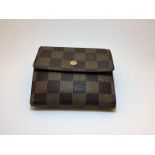 Authentic Louis Vuitton Damier Ebene Elise Wallet. It is constructed of durable signature ebene