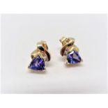 Tanzanite stud earrings with 2 diamonds per earring. 14k yellow gold.