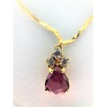 Pear shaped garnet pendant with 3 diamonds on 17'' gold chain. 18k yellow gold.