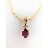 Oval shaped garnet pendant with 1 diamond on 16'' gold chain. 14k yellow gold. Tital diamond