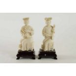 Stel ivoren sculpturen van zittende dames met instrument op houten voet, China, h. 13 cm.