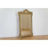 Rectangular faceted mirror in gold lacquer frame, crest with acanthus leaf, h. 140 cm.