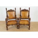 two oakwood armchairs with brown leather, on griffen legs Stel eiken rijkgestoken armstoelen met
