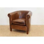 Engelse clubfauteuil geheel overtrokken met leer en rustend op houten poten An English leather