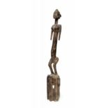 Mali, Dogon, satimbe masker, bekroond met staand vrouwfiguur. Onderarmen ontbreken. h. 94 cm.