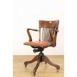 Eikenhouten in hoogte verstelbare bureaufauteuil, ca. 1900, met rode kunststoffen bekleding. Op