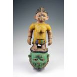 Yoruba, Gelede masker; helmmasker bekroond met staand vrouwfiguur met rokje. Met polychrome