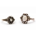 Twee zilveren en gouden entourage ringen één gezet met een ovale cabochon geslepen opaal (