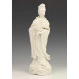 China, fraai gevormde blanc-de-Chine Guanyin, staande met lotusbloem in de hand. h. 29 cm. Herkomst: