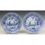China, paar blauw-wit porseleinen borden, Kangxi, met decor van lange lijzen bij hekwerk, de rand