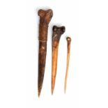 PNG, Abelam, twee ceremoniële benen dolken en een benen haarpen; een dolk met rotan banden versierd.