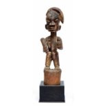 Nigeria, Yoruba, staand figuur op hoge cilindervormige basis, haardracht in een streng naar