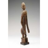 Mali, Bamana, staand figuur met langgestrekte armen gebogen langs het lichaam, gebogen nek,