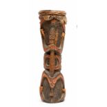 Asmat, houten trommel met greep in de vorm van gestileerde bidsprinkhaan en op lichaam, handjes en